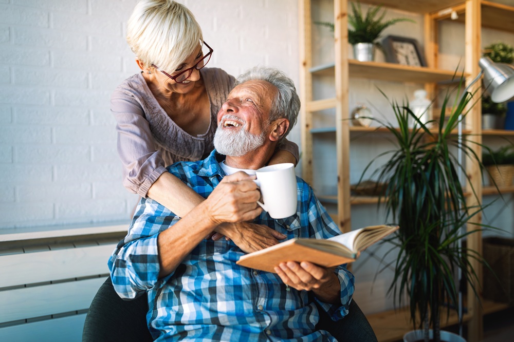 Smiling elderly couple relaxing together indoors, representing safe and comfortable living spaces – Home Remodeling Consulting