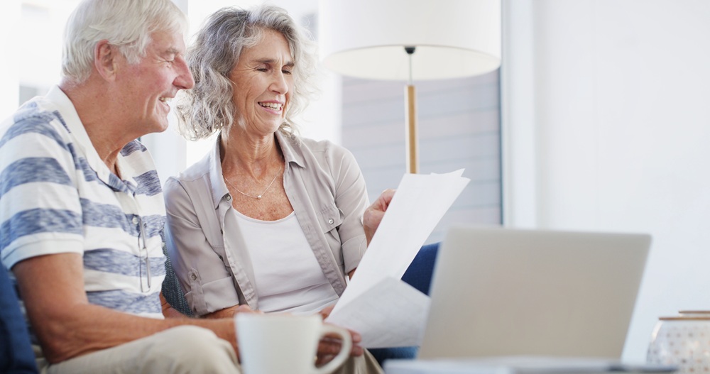 Couple Reviewing Home Documents and Planning New Build – New Construction Guidance Older couple reading paperwork beside laptop while preparing for home project with new construction guidance – New Construction Guidance